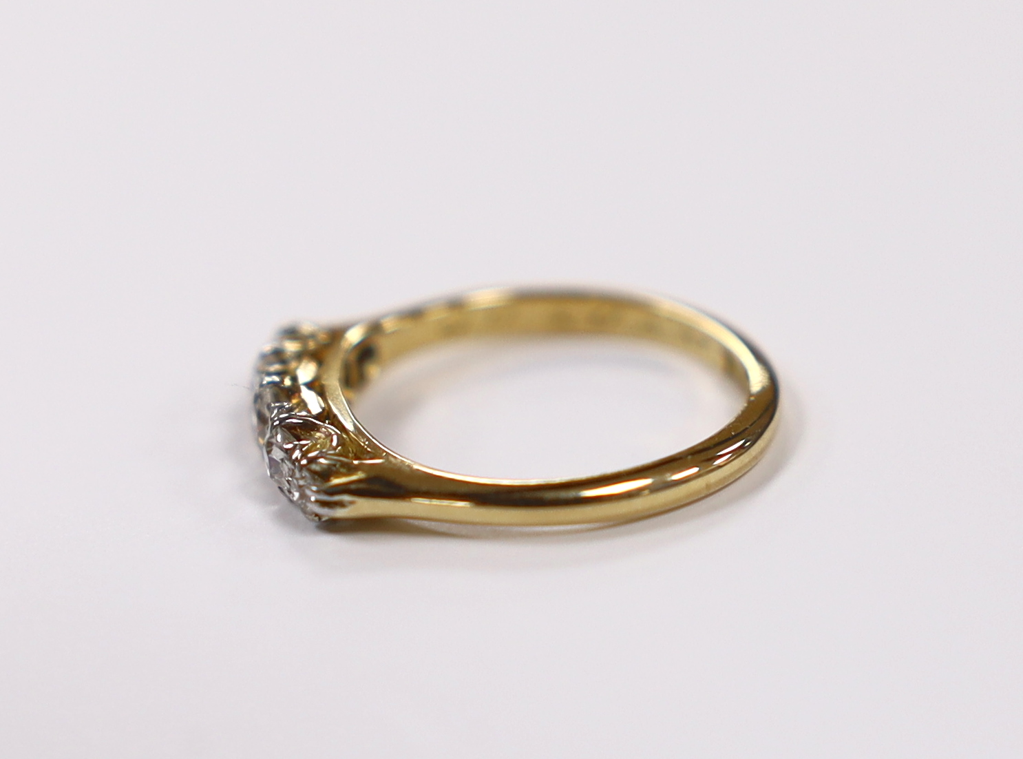 A 1920's 18ct, plat and graduated five stone diamond set half hoop ring, size K/L, gross weight 2.6 grams.